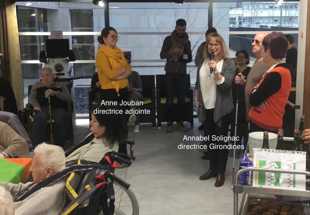 vœux de la ville de Lyon pour 2018 - Annabel Solignac au micro, Anne Jouban debout face à elle et quelques résidents.